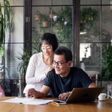 Senior Chinese couple talking about home finances.