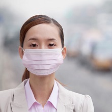 Chinese woman wearing face mask because of air pollution in the city